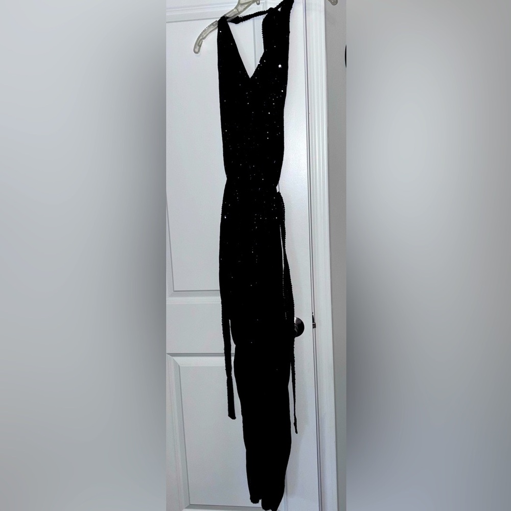 Sequined black halter jumpsuit that ties around neck. Size S. 100% polyester.